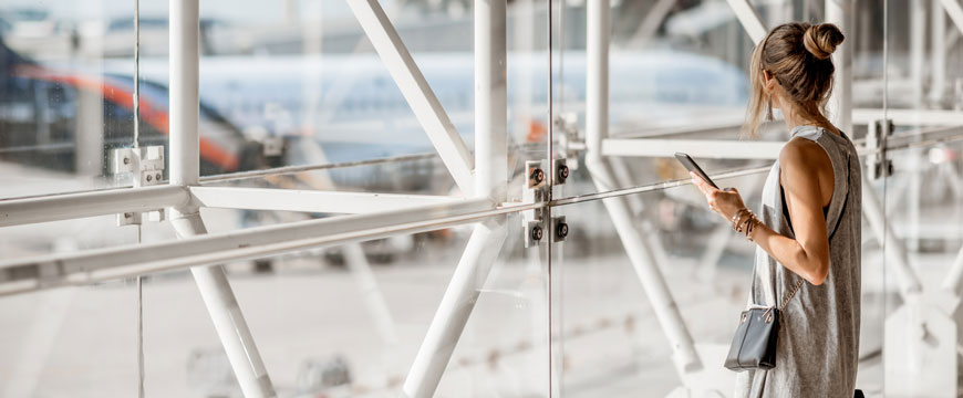 Girl at Airport, Holding a Phone, and Looking at a Plane