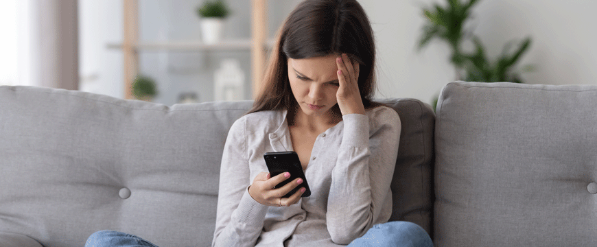 Girl Looking at a Phone in Confusion