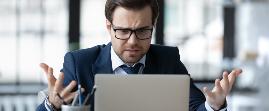Man looking at his computer in confusion